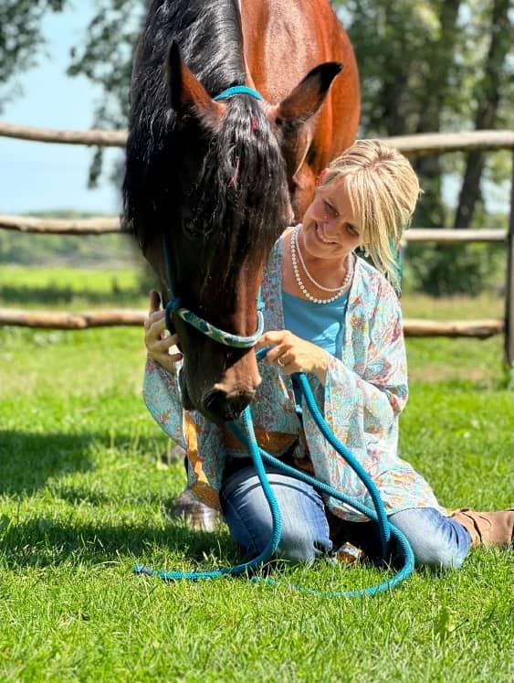 Groundwork in the grass, horse lowering its head to meet her
